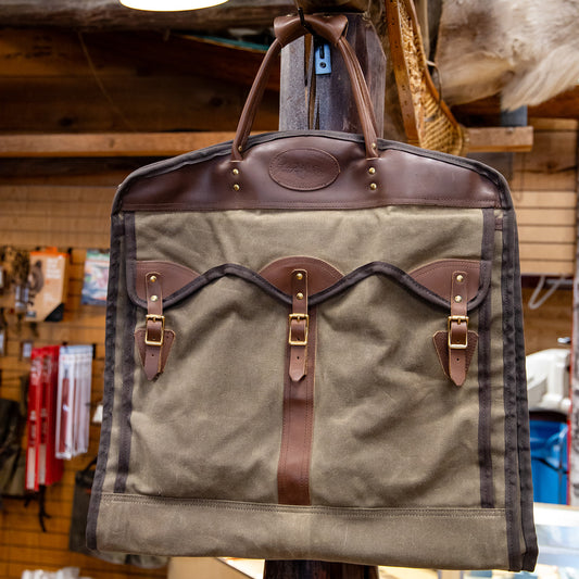 A waxed canvas and leather premium garment bag hanging in the store where they make them in Duluth, Minnesota.