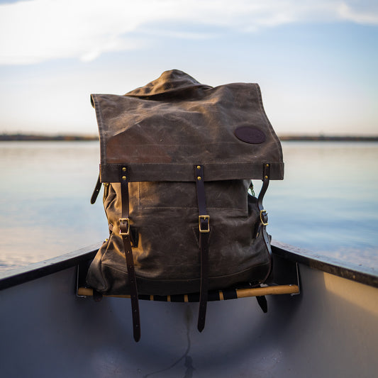 Frost River's Old No. 7 Canoe Pack sitting in a canoe. This is a traditional style waxed canvas canoe pack.