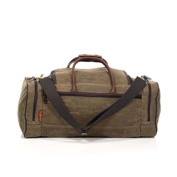 Handmade duffle bag with cotton webbed shoulder strap and zippered exterior pockets.