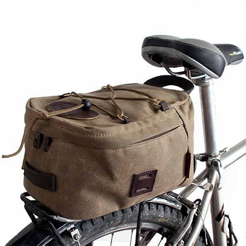 The box shape of the Taconite Trail Bike Trunk bag fits well on a back wheel rack and is secured onto the bike with sturdy leather straps and solid brass buckles.