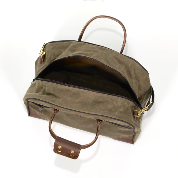Luggage bag with large zippered opening, and premium leather grab handles.