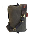 Back view of sling pack made with green and tan waxed canvas with a durable cotton webbed shoulder strap and a quick release solid brass hook.