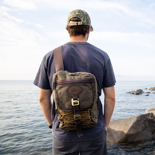 A man wearing a waxed canvas cross body bag.