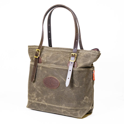 Side view of a waxed canvas and leather tote bag.