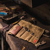 Waxed canvas Tool Roll laying open on a work bench.