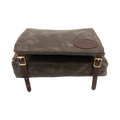 A waxed canvas canoe seat pad that has an attached bag that hangs underneath the canoe seat. 