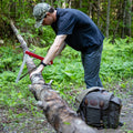 A man talking a folding saw out of Frost River's waxed canvas saw bag. 