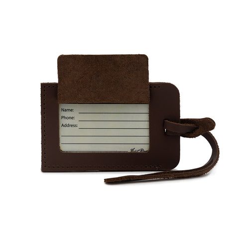 Brown leather luggage tag with a white label for writing information on a white background