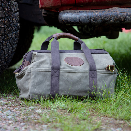 Gladstone Bag sits on the ground next to a truck tire. 