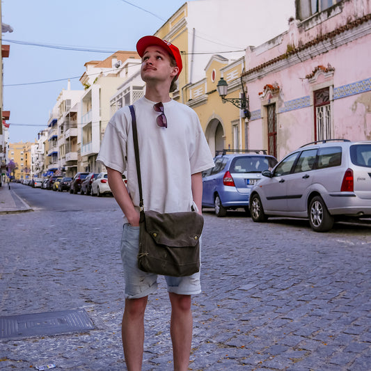 A man wearing an American made waxed canvas satchel. 