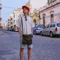 A man wearing an American made waxed canvas satchel. 