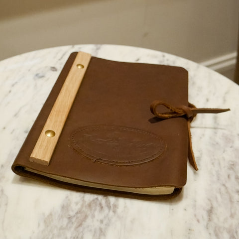 A leather journal sitting on a side table