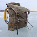 A waxed canvas canoe pack with buckskin padded straps and a traditional tumpline. 