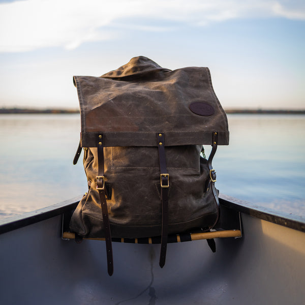 Frost River's Old No. 7 Canoe Pack sitting in a canoe. This is a traditional style waxed canvas canoe pack. 