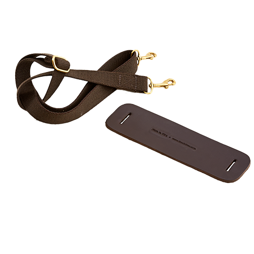 A brown leather shoulder pad with brass hardware, designed to be attached to a strap.