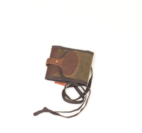 Made with an olive green waxed canvas that is paired well with the brown cotton binding and shoulder strap.