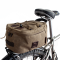 The box shape of the Taconite Trail Bike Trunk bag fits well on a back wheel rack and is secured onto the bike with sturdy leather straps and solid brass buckles.