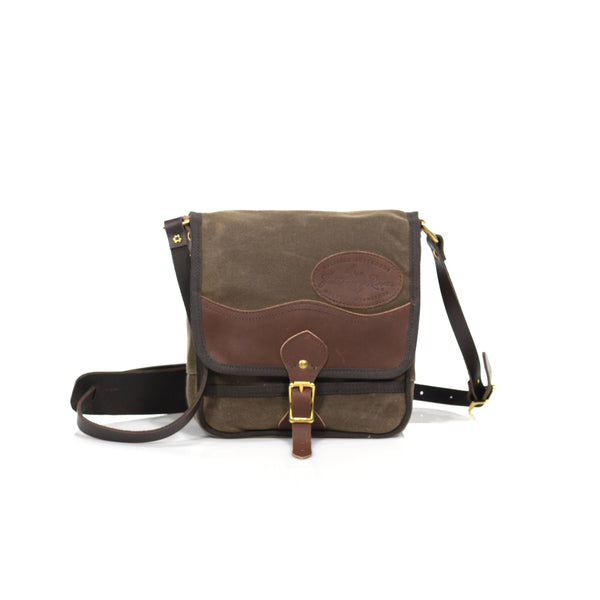 Timeless shoulder bag made from waxed canvas, premium leather, and solid brass.