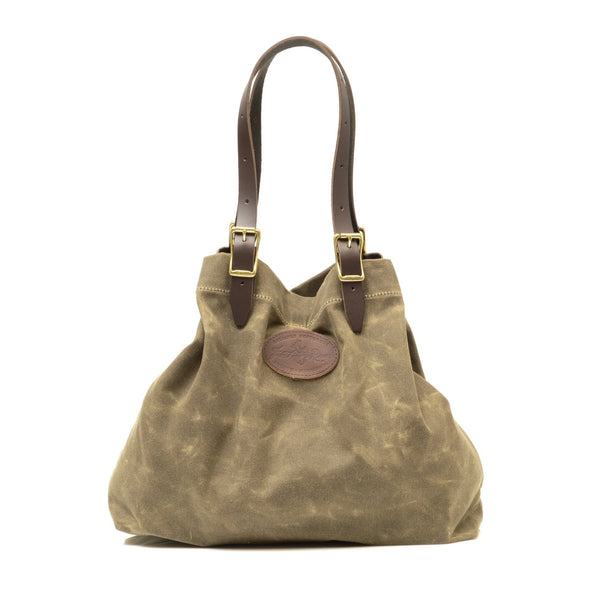 Large tote with adjustable leather straps connected with solid brass buckles.