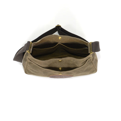 The front and main pocket of the bag is closed with a brass snap.
